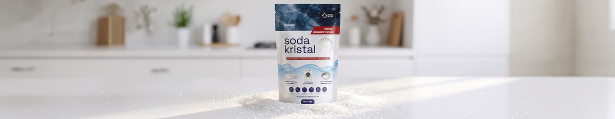 Aydınlık bir mutfak tezgahında dökülmüş soda kristali üzerinde duran Soda Kristal 1 kg paketi