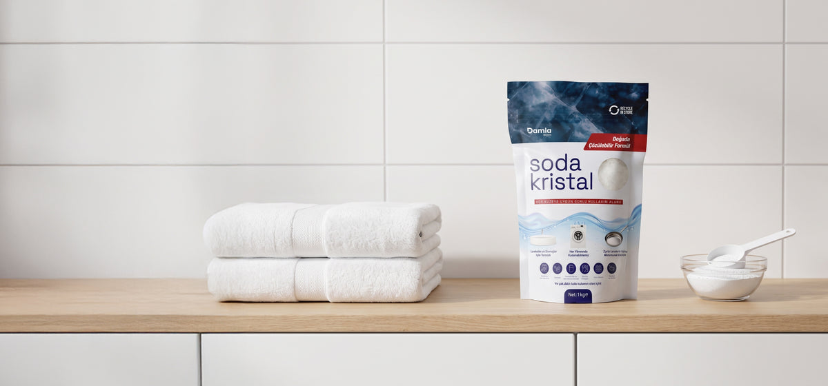 Banyo tezgahında katlanmış beyaz havlular, Soda Kristal paketi ve kasede soda kristali
